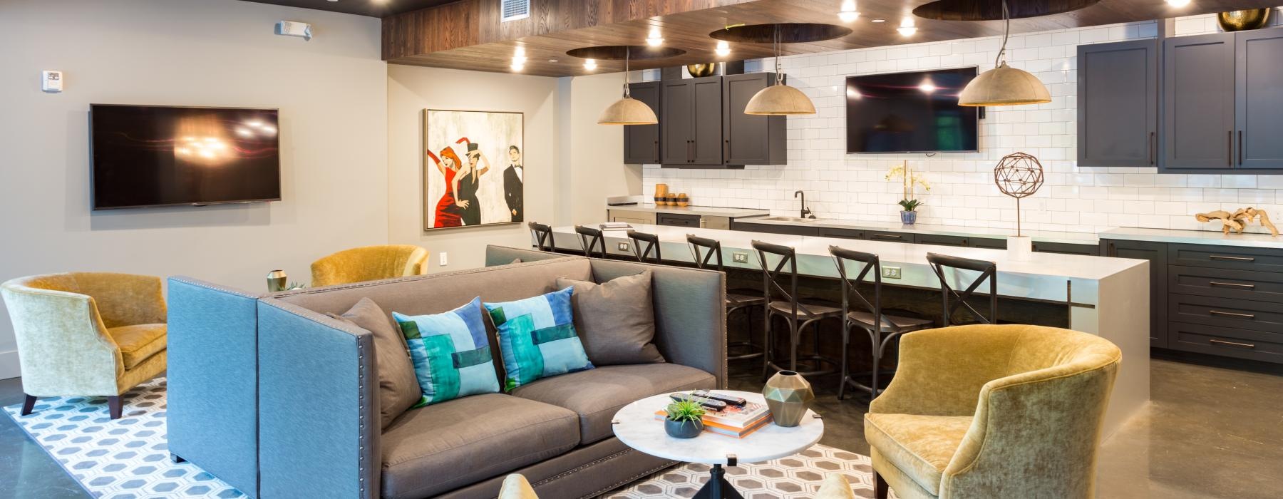 a large living room with a bar and chairs